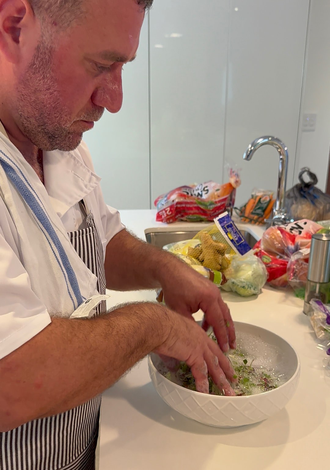 Chef Leo Rudnitsky washing micro greens for a kosher dinner service in Florida
